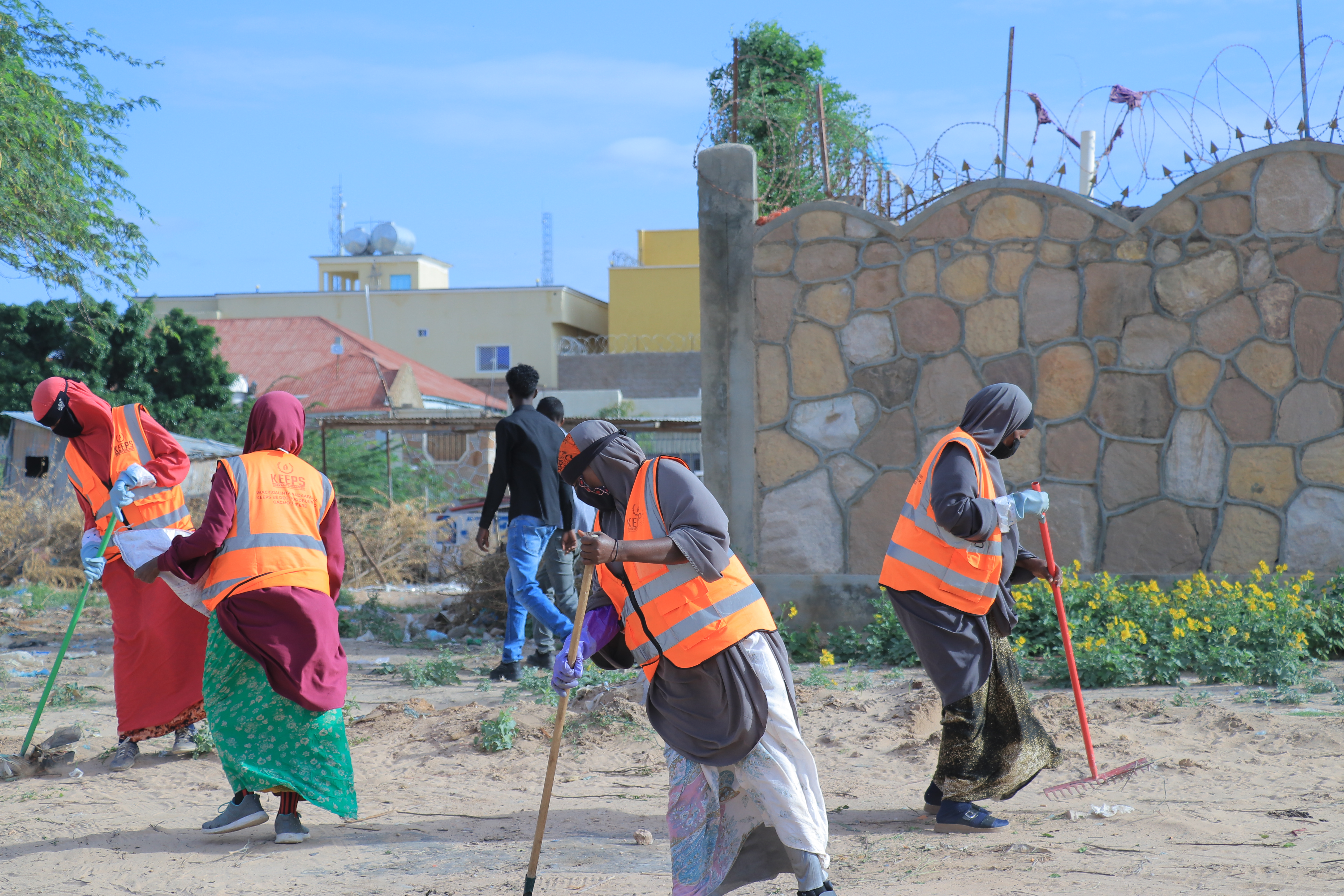 Female KEEPS employees working to clean up a beach area