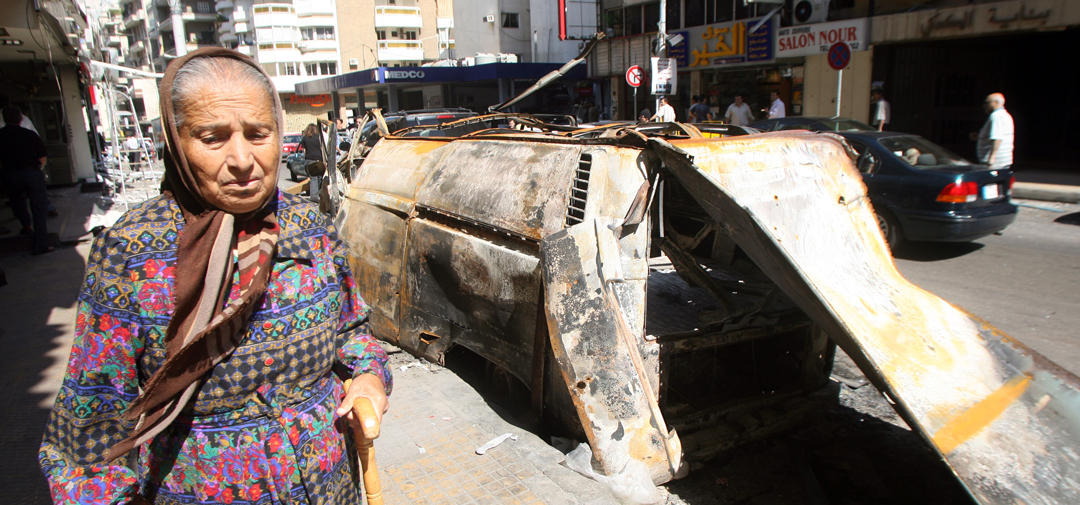 A Lebanese woman walks past a wrecked car May 10, 2008 in Beirut, Lebanon. (Photo by Salah Malkawi/Getty Images)