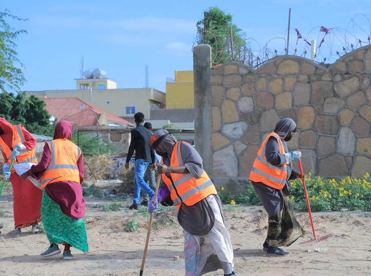 Female KEEPS employees working to clean up a beach area