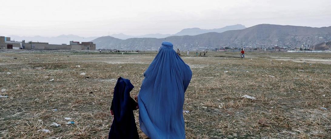 Afghan woman walking with a child