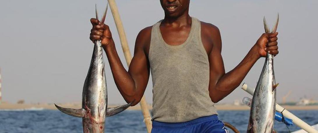 Somali man holding two fish