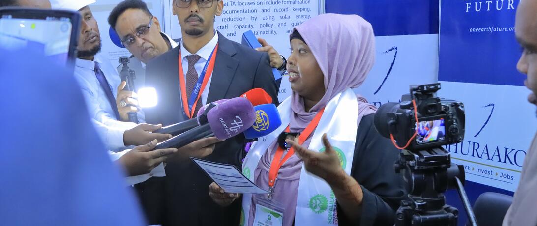 Sahra speaking into a microphone at the Somaliland Investment Expo