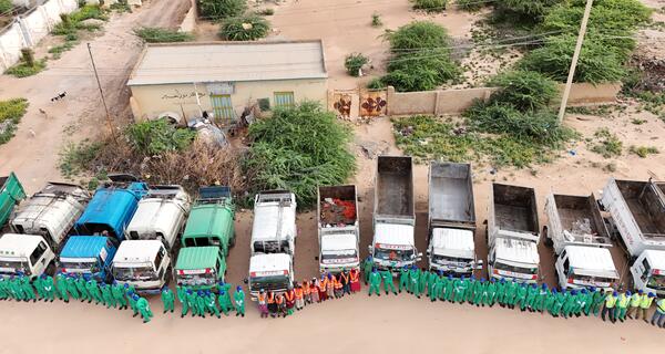 Overhead shot of KEEPS employees lined up nicely in front of the work trucks