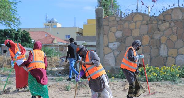 Female KEEPS employees working to clean up a beach area