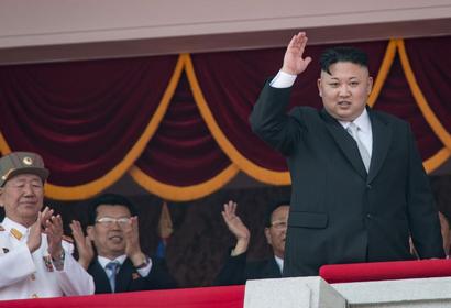 North Korean leader Kim Jong Un waves from a balcony following a military parade in Pyongyang on April 15, 2017.