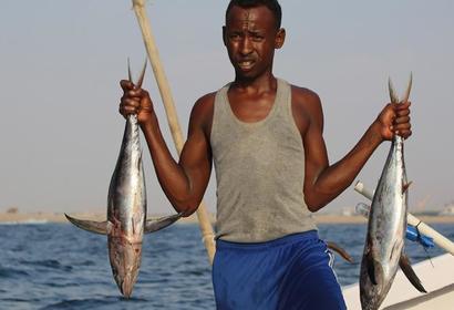Somali man holding two fish