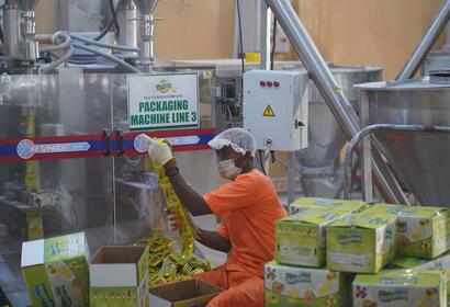 ILO Tango employee boxing up drink mix packets in manufacturing facility 