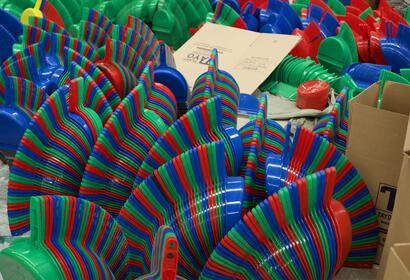 Blue, red and green plastic dust pans stacked to look like stripes