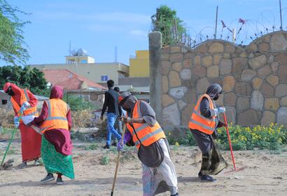 Female KEEPS employees working to clean up a beach area